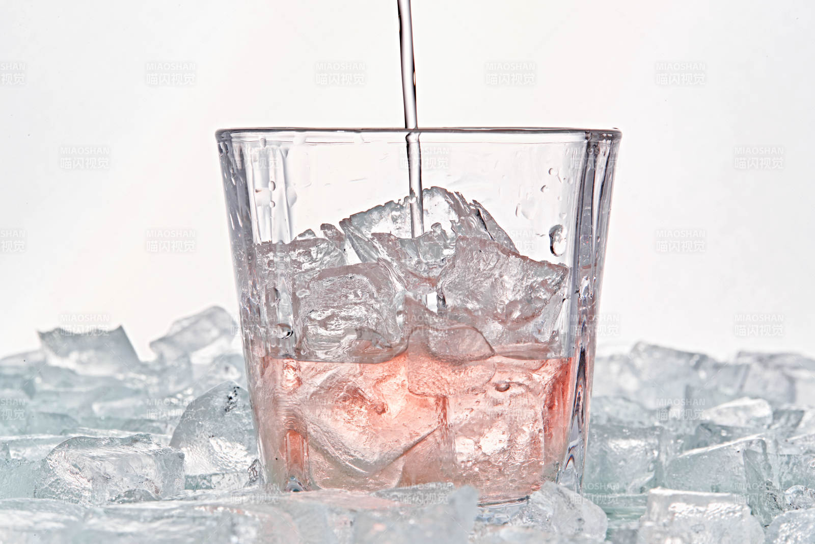 布满冰块的酒杯中的清凉桃子味预调酒图片