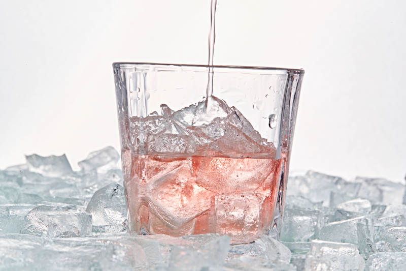 布满冰块的酒杯中的清凉桃子味预调酒图片