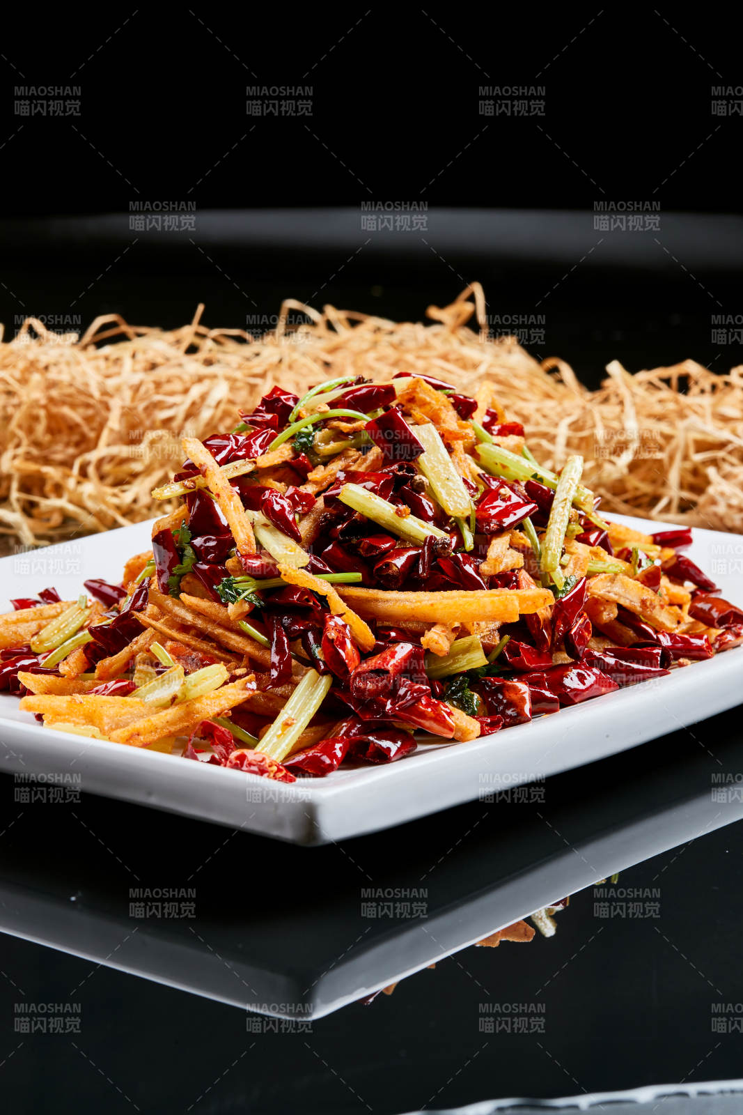 白色瓷盘装的的香辣西芹薯条鱿鱼身图片