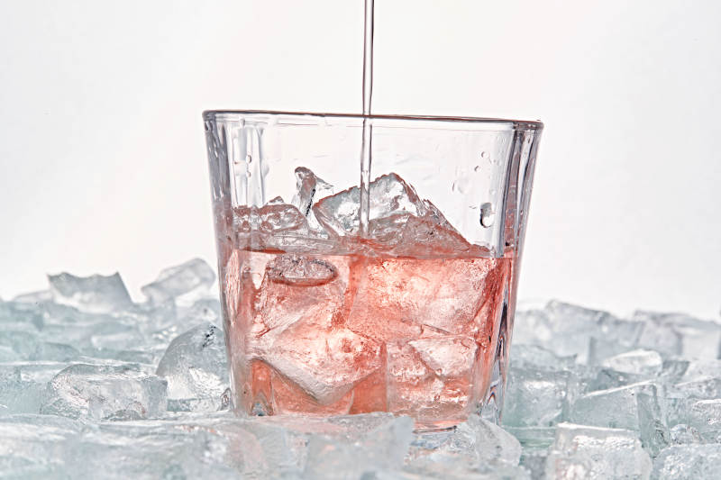 布满冰块的酒杯中的清凉桃子味预调酒图片