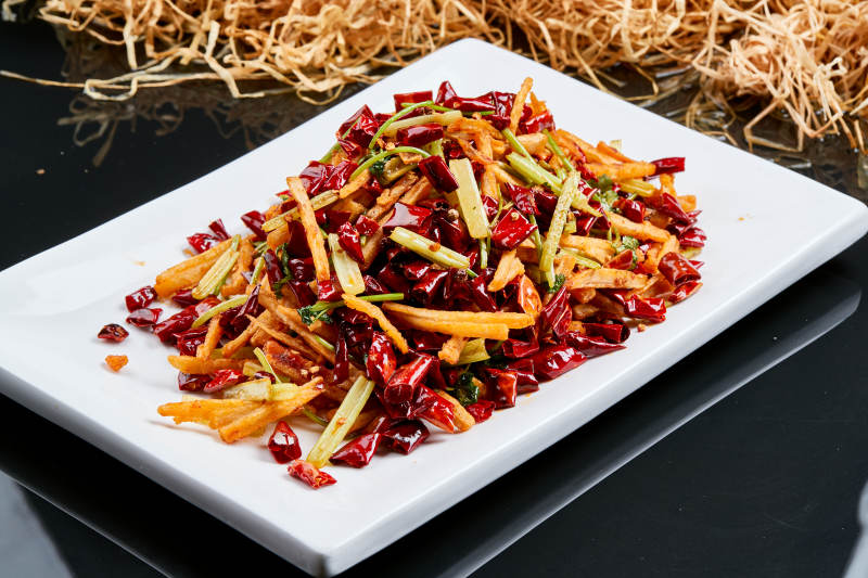 白色瓷盘装的的香辣西芹薯条鱿鱼身图片