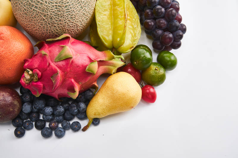 白色背景上摆放的生鲜混合水果图片