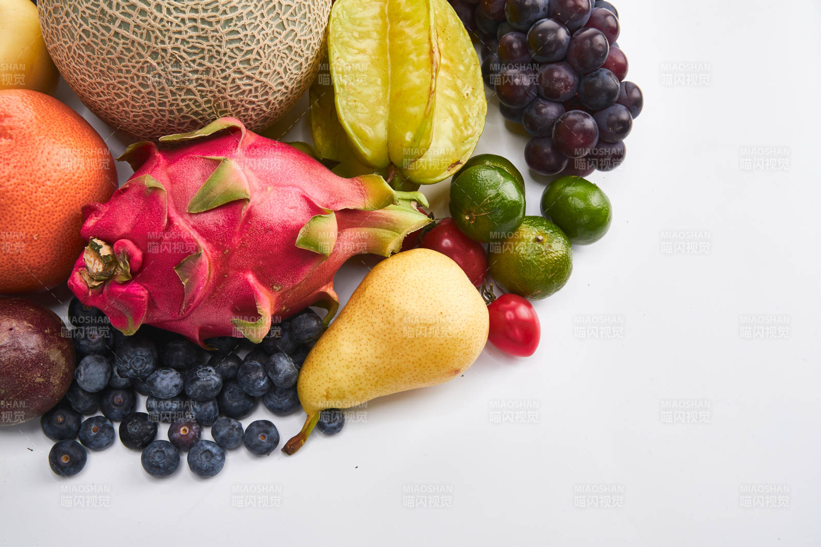 白色背景上摆放的生鲜混合水果图片
