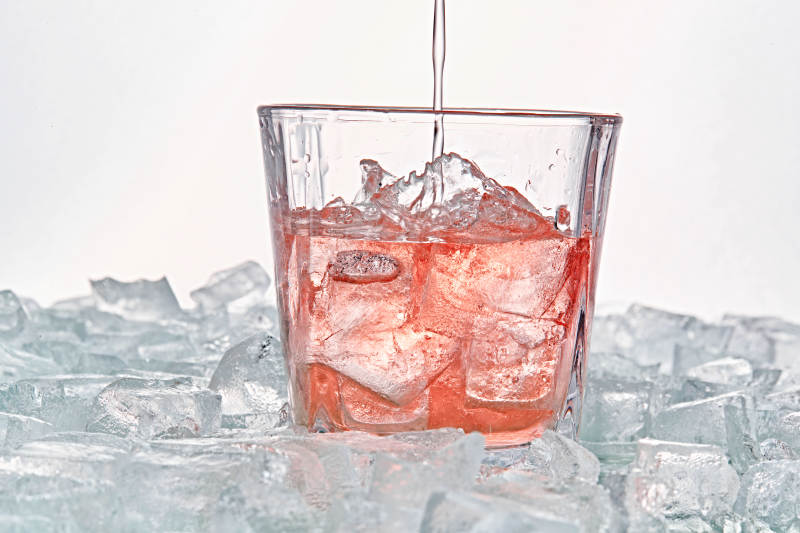 布满冰块的酒杯中的清凉桃子味预调酒图片