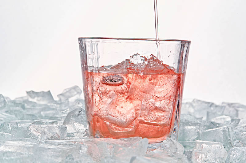 布满冰块的酒杯中的清凉桃子味预调酒图片