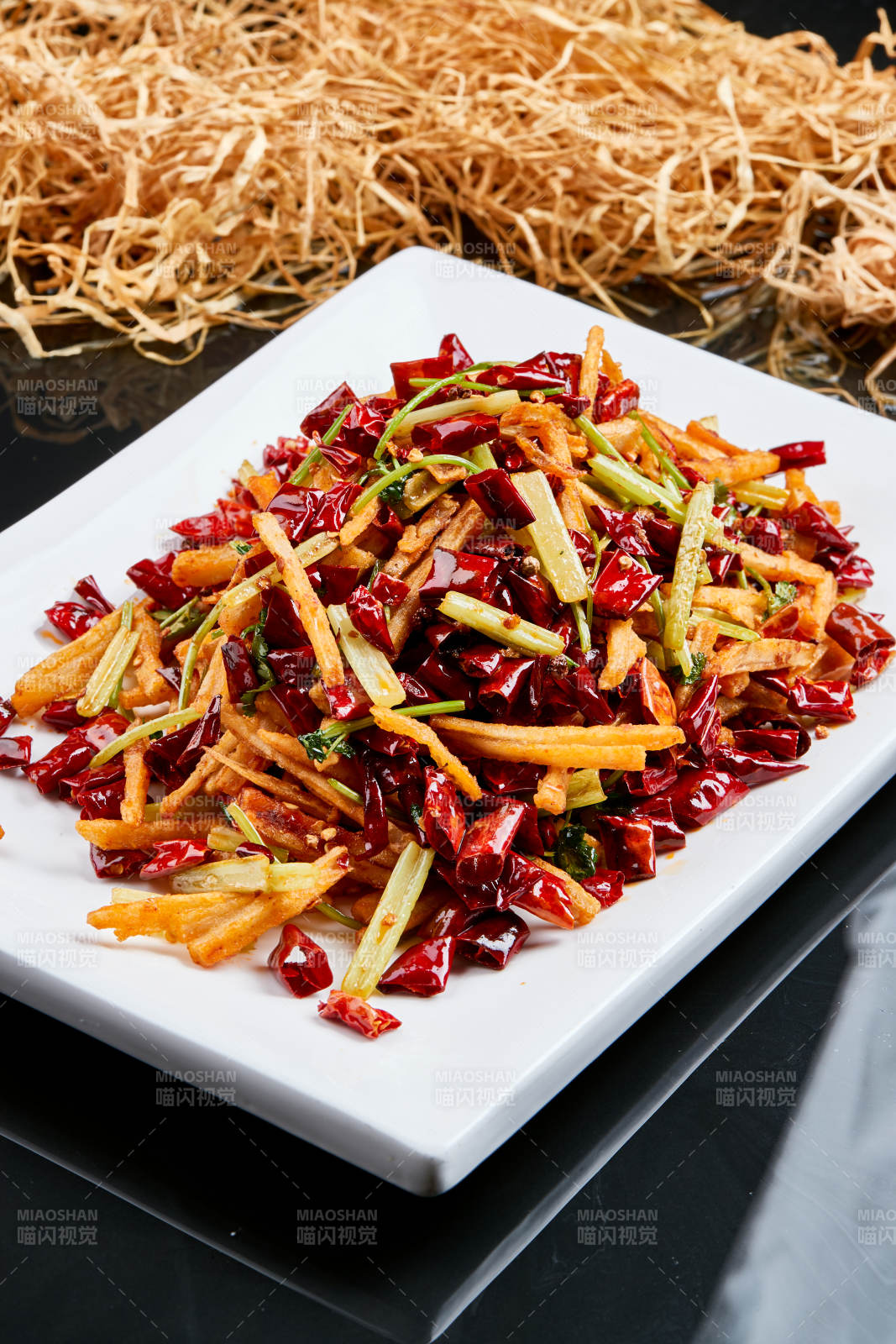 白色瓷盘装的的香辣西芹薯条鱿鱼身图片