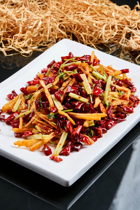 白色瓷盘装的的香辣西芹薯条鱿鱼身图片