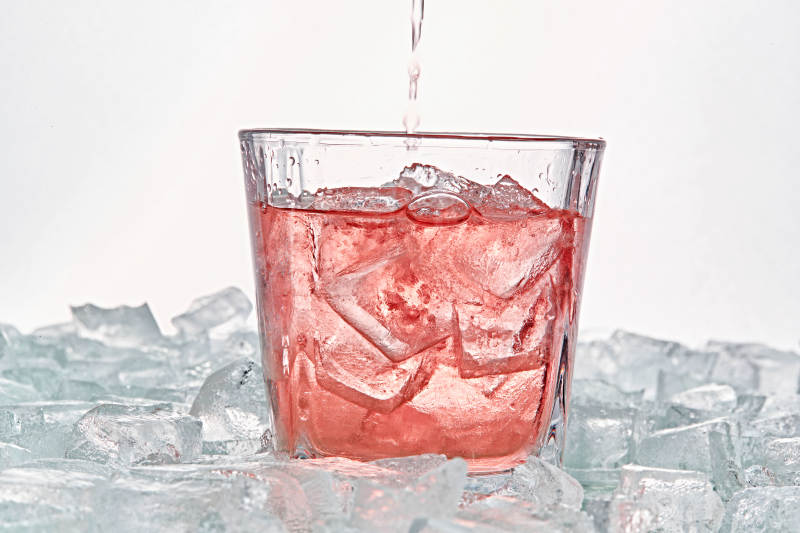 布满冰块的酒杯中的清凉桃子味预调酒图片