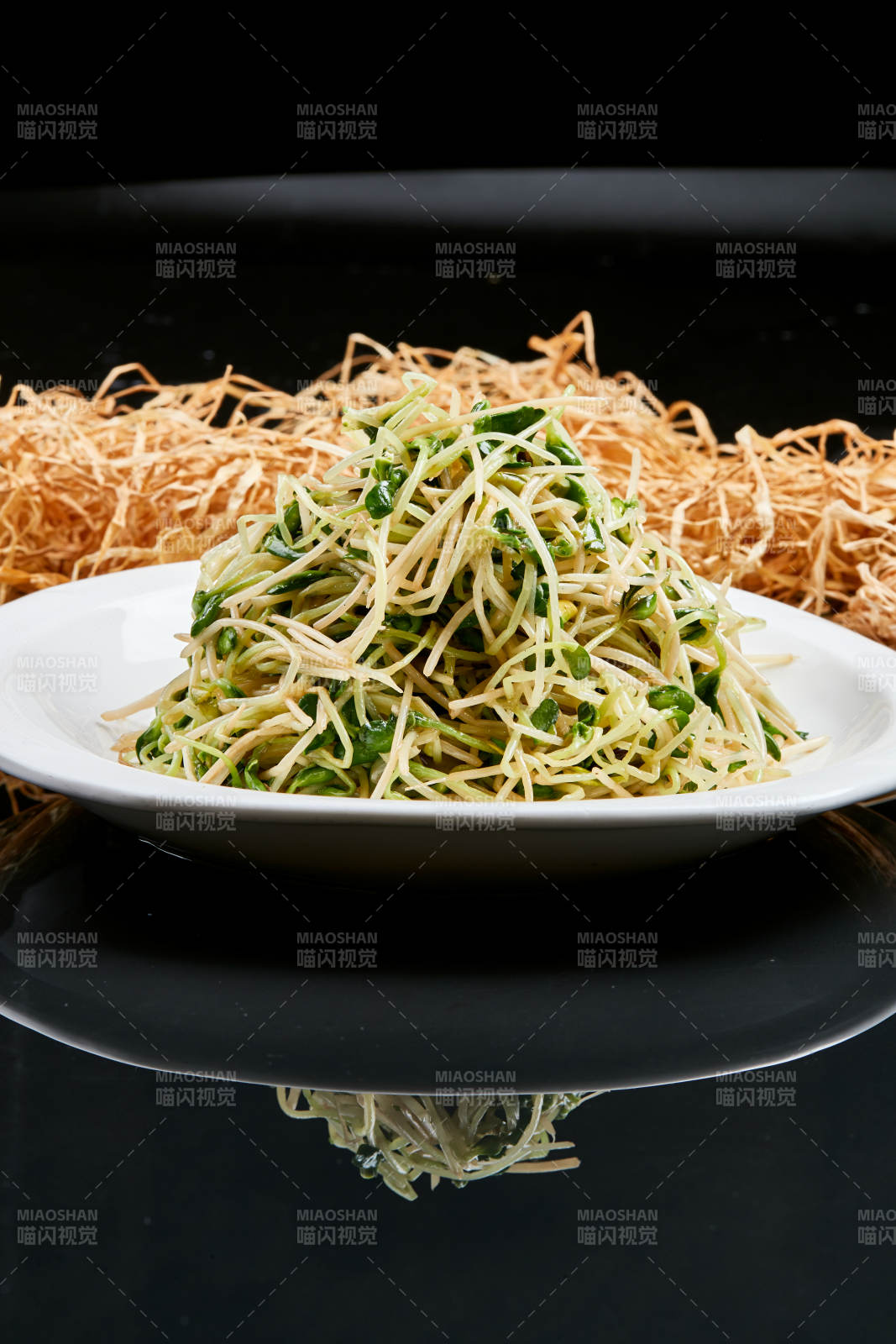 白色瓷盘装的凉拌香椿黑豆苗图片