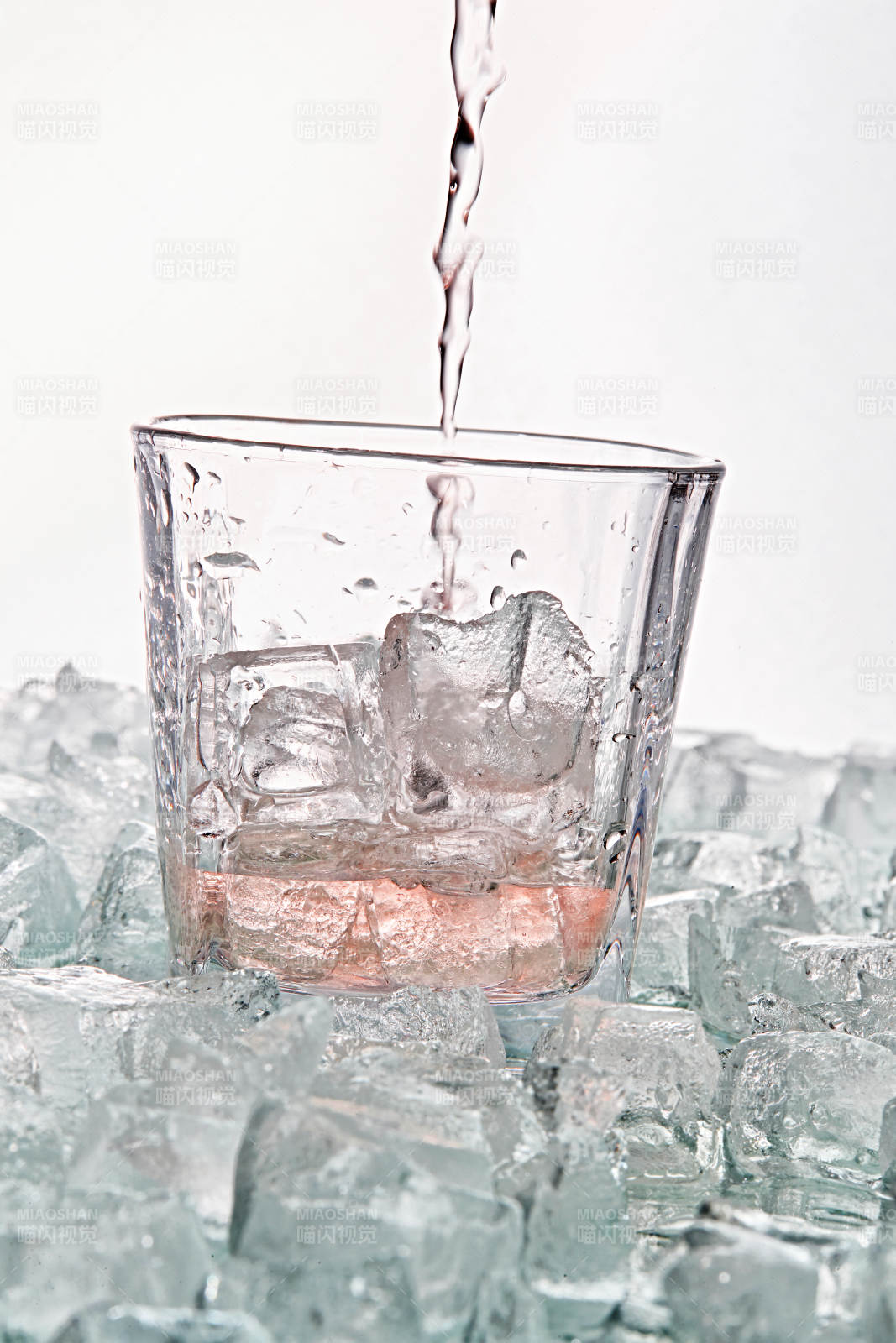 布满冰块的酒杯中的清凉桃子味预调酒图片