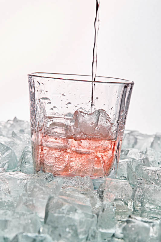 布满冰块的酒杯中的清凉桃子味预调酒图片