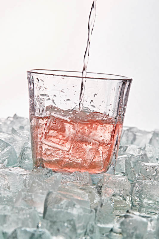 布满冰块的酒杯中的清凉桃子味预调酒图片