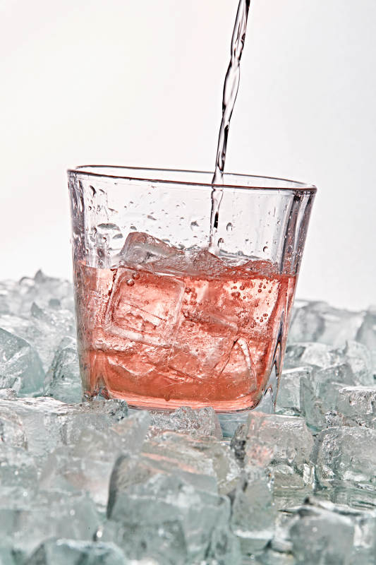 布满冰块的酒杯中的清凉桃子味预调酒图片