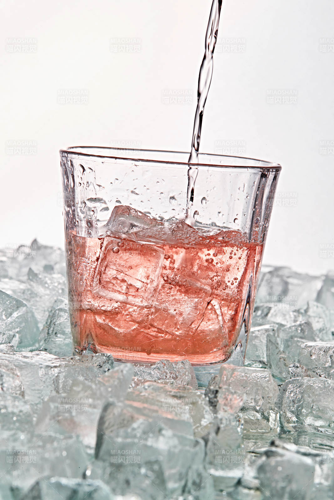 布满冰块的酒杯中的清凉桃子味预调酒图片