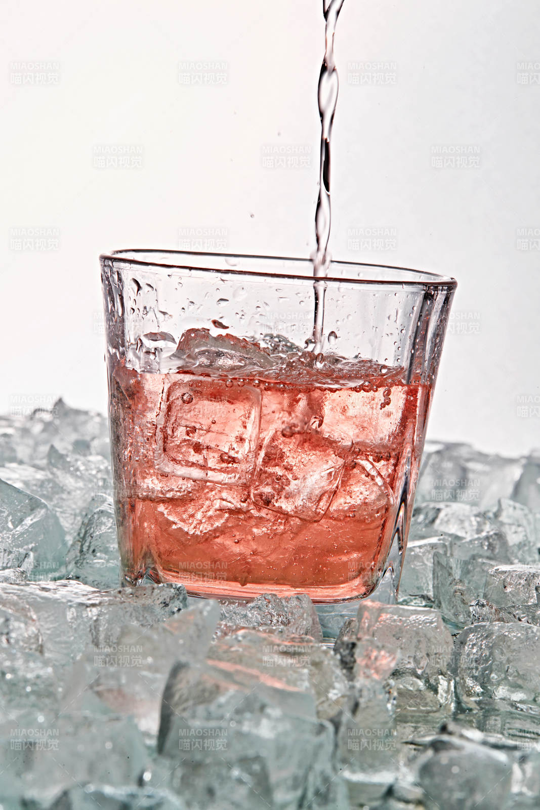 布满冰块的酒杯中的清凉桃子味预调酒图片
