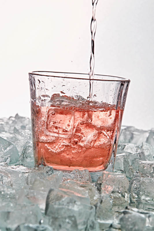 布满冰块的酒杯中的清凉桃子味预调酒图片