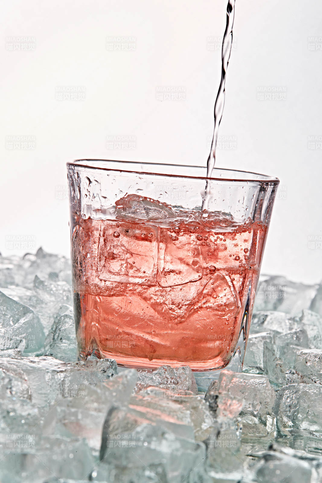 布满冰块的酒杯中的清凉桃子味预调酒图片