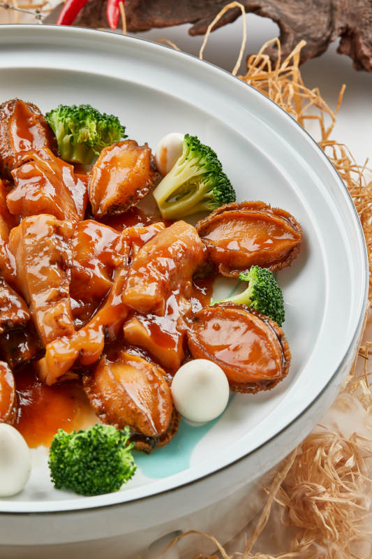 精美餐具装的浇汁鲜鲍鱼烧梅花参图片