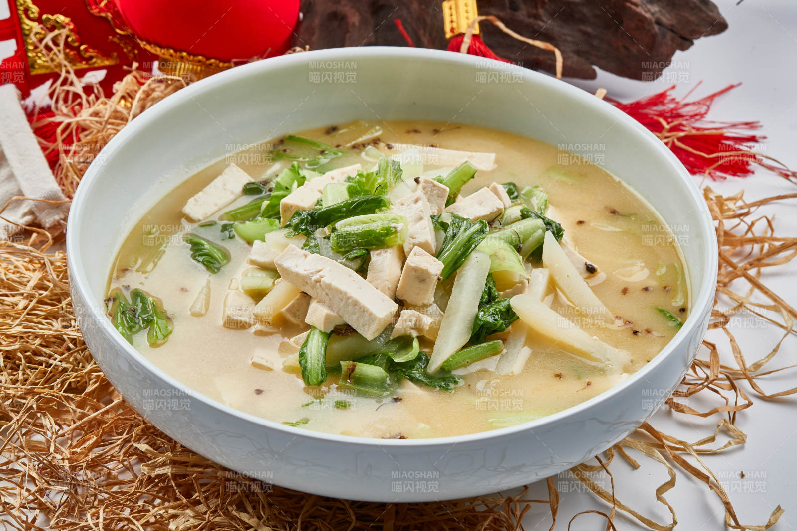 白色瓷餐具装的浓汤小白菜土豆炖豆腐图片