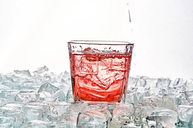 布满冰块的酒杯中的清凉桃子味预调酒图片