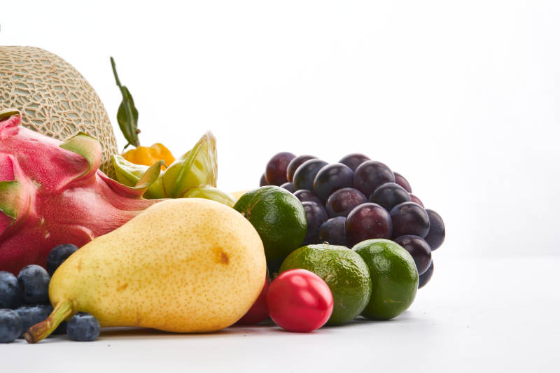 白色背景上摆放的生鲜混合水果图片