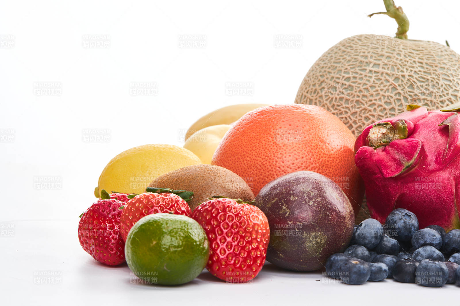 白色背景上摆放的生鲜混合水果图片