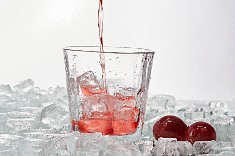 布满冰块的酒杯中的清凉桃子味预调酒图片