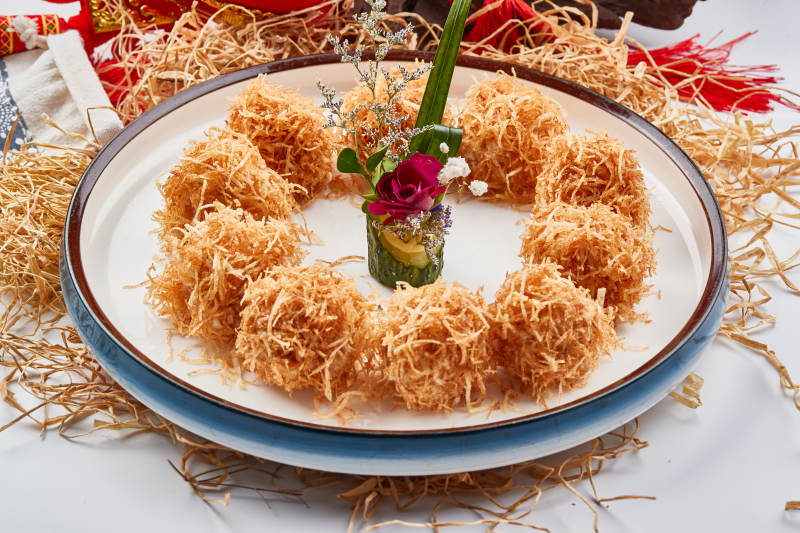 白色瓷盘装的金丝油炸大虾球图片