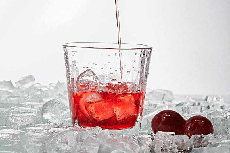布满冰块的酒杯中的清凉桃子味预调酒图片