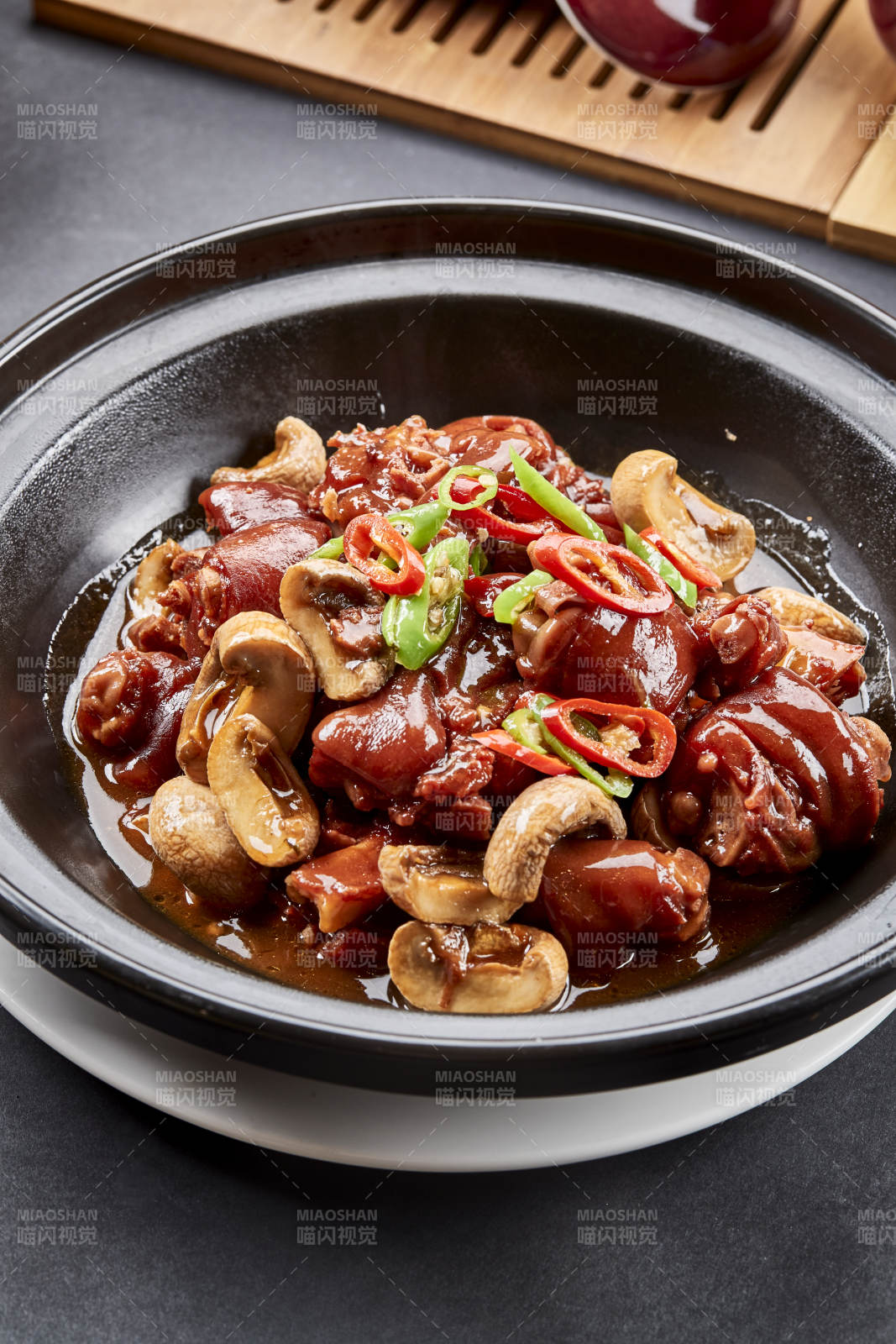 黑砂锅装的砂锅鲜口蘑烧猪脚块图片