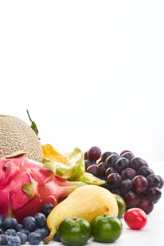 白色背景上摆放的生鲜混合水果图片