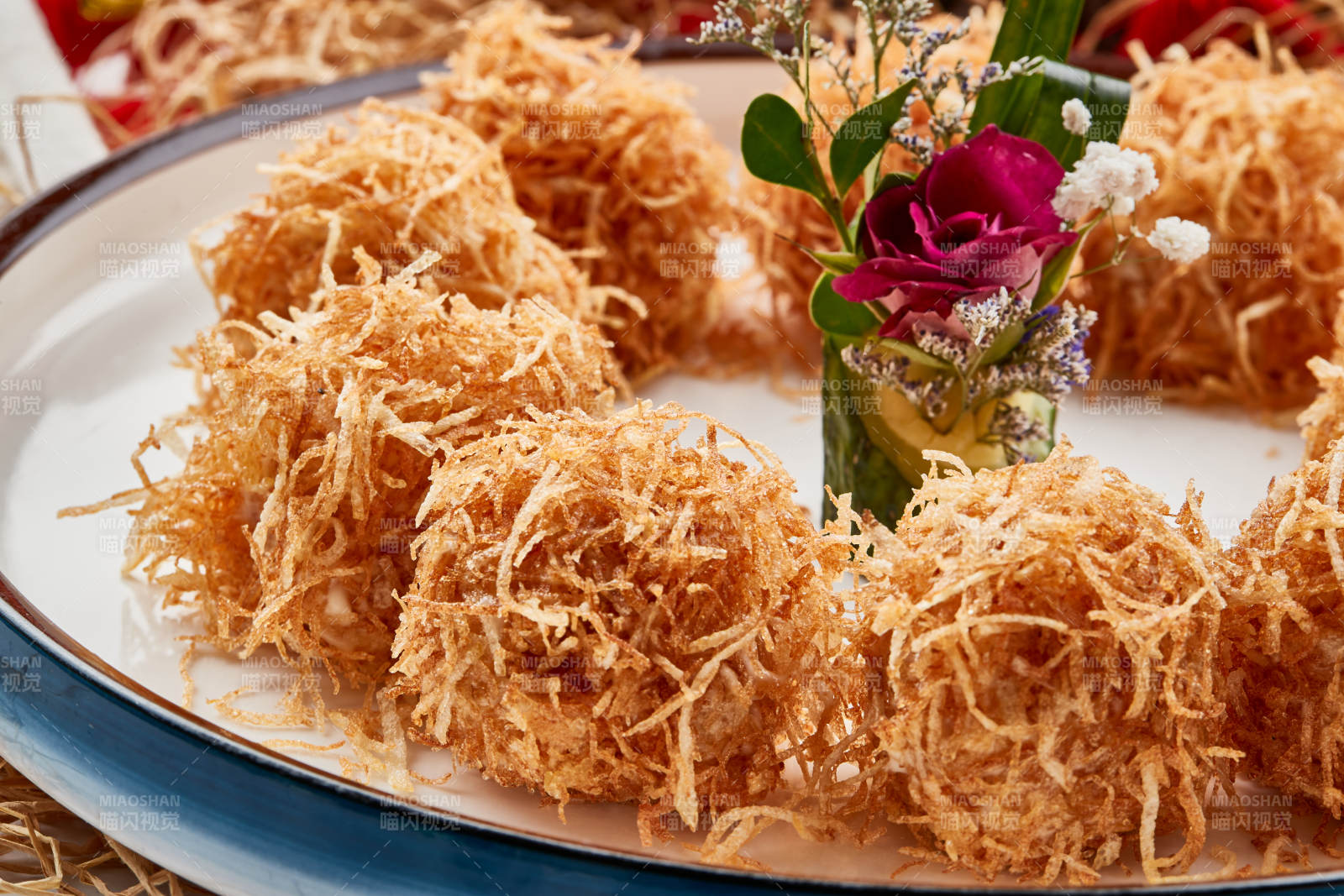 白色瓷盘装的金丝油炸大虾球图片