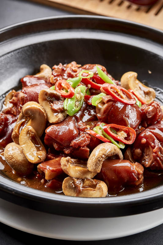 黑砂锅装的砂锅鲜口蘑烧猪脚块图片