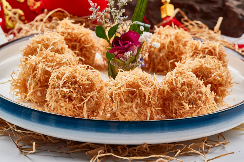 白色瓷盘装的金丝油炸大虾球图片