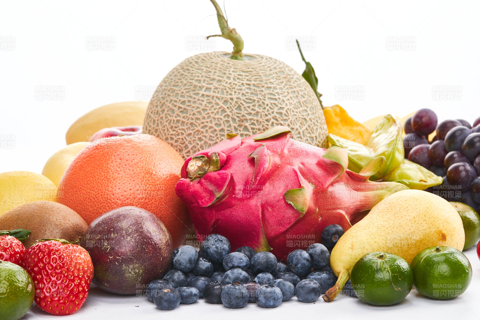 白色背景上摆放的生鲜混合水果图片