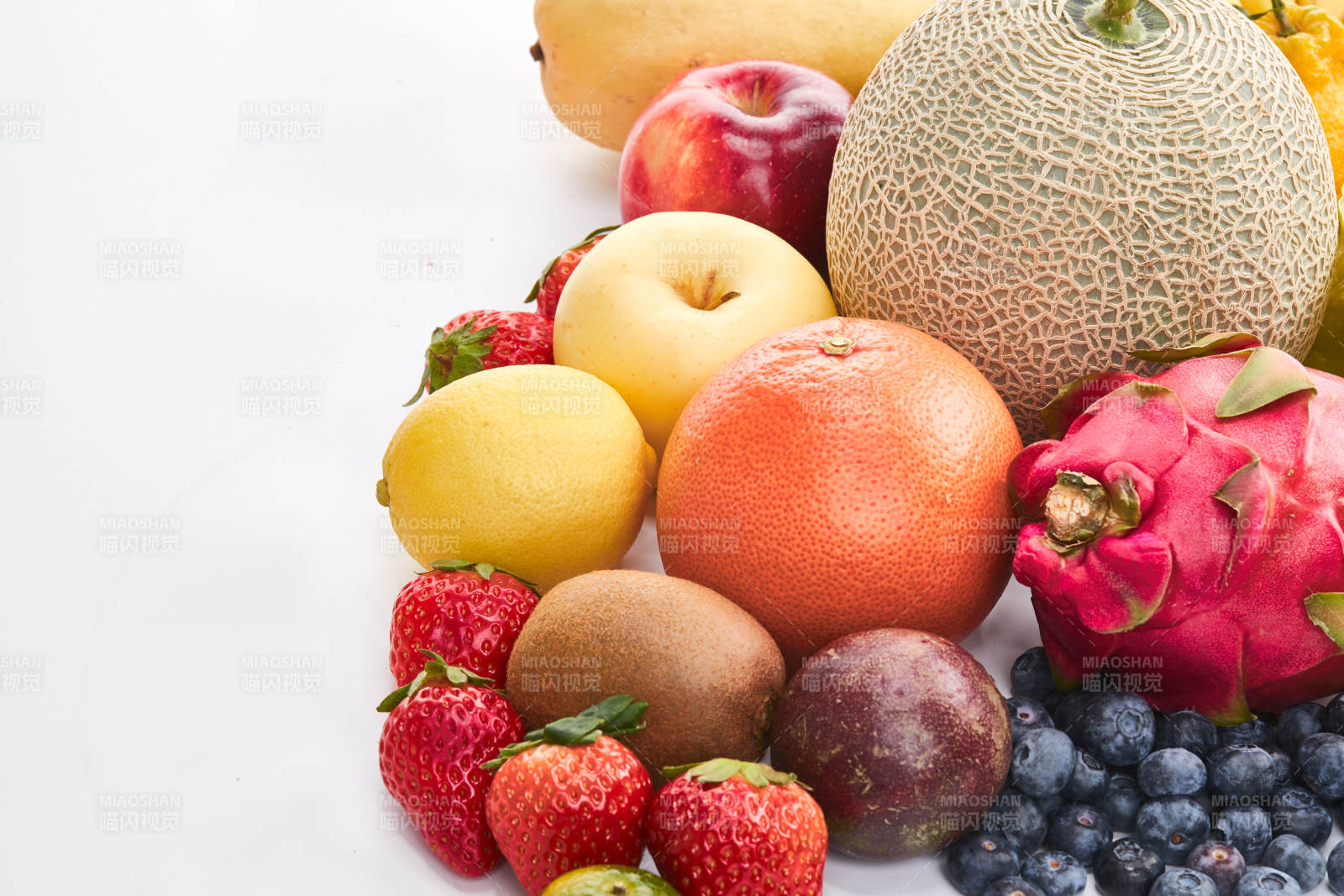 白色背景上摆放的生鲜混合水果图片