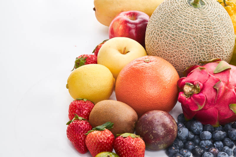 白色背景上摆放的生鲜混合水果图片