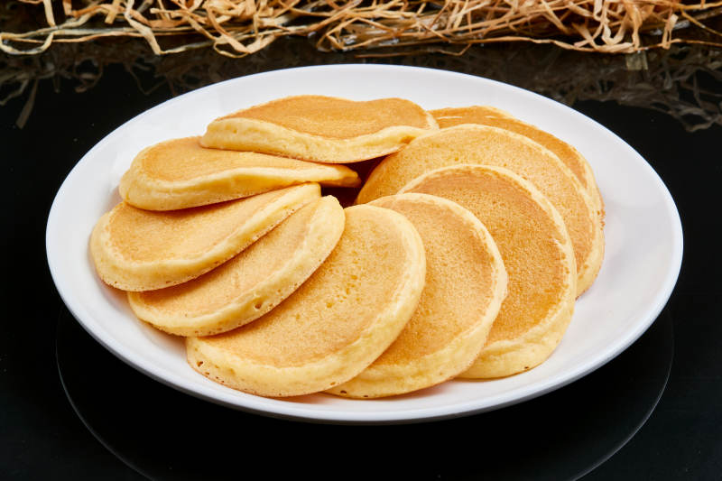 白色瓷盘装的香煎玉米面鸡蛋滩簧饼图片