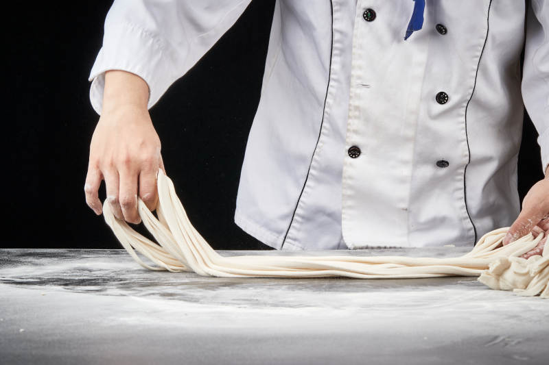 技艺精湛的拉面师在展示拉面制作图片