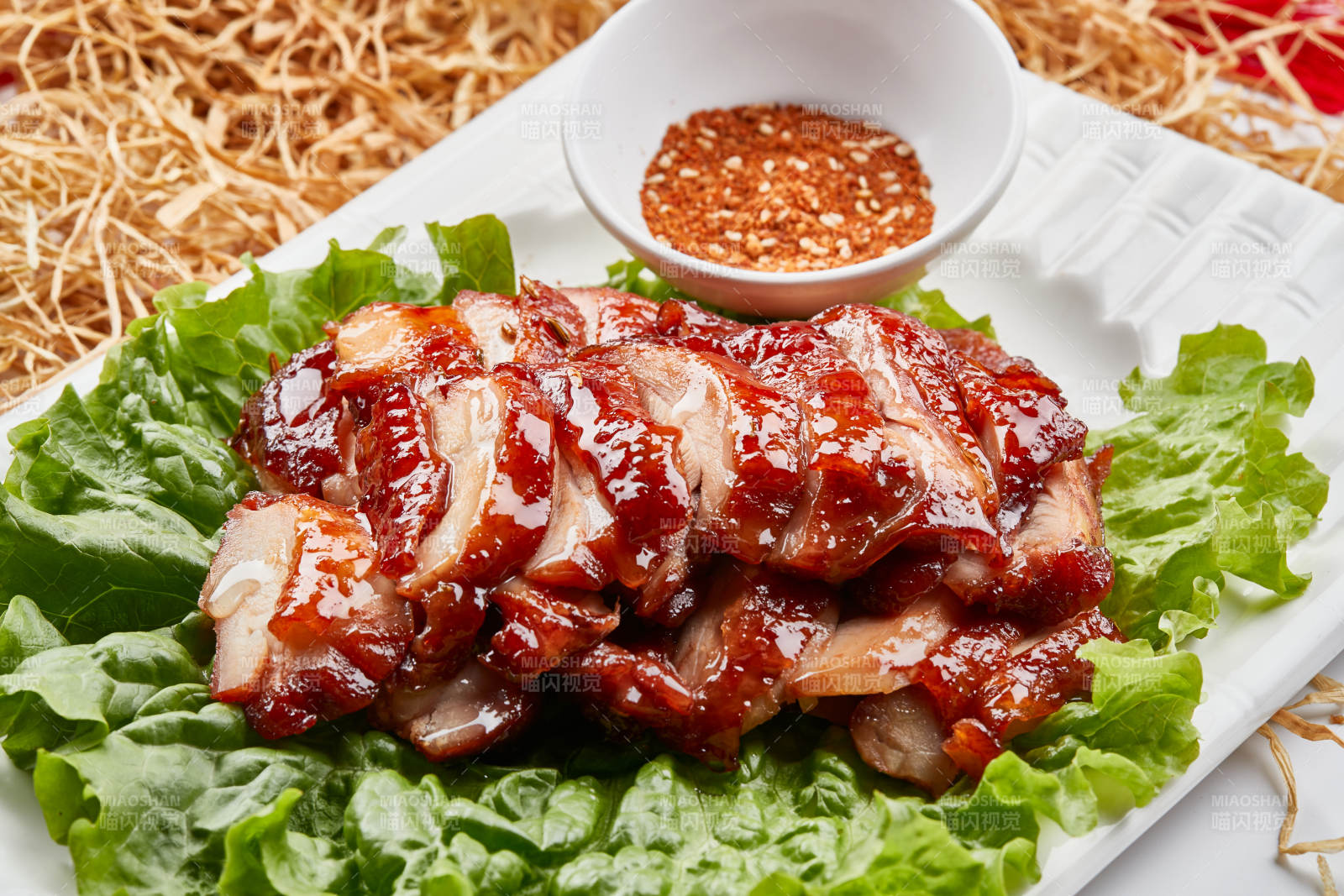 白色瓷盘装的蜜汁叉烧鸡腿肉图片