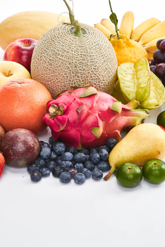 白色背景上摆放的生鲜混合水果图片