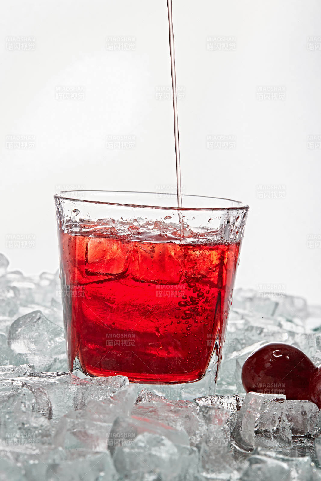 布满冰块的酒杯中的清凉桃子味预调酒图片