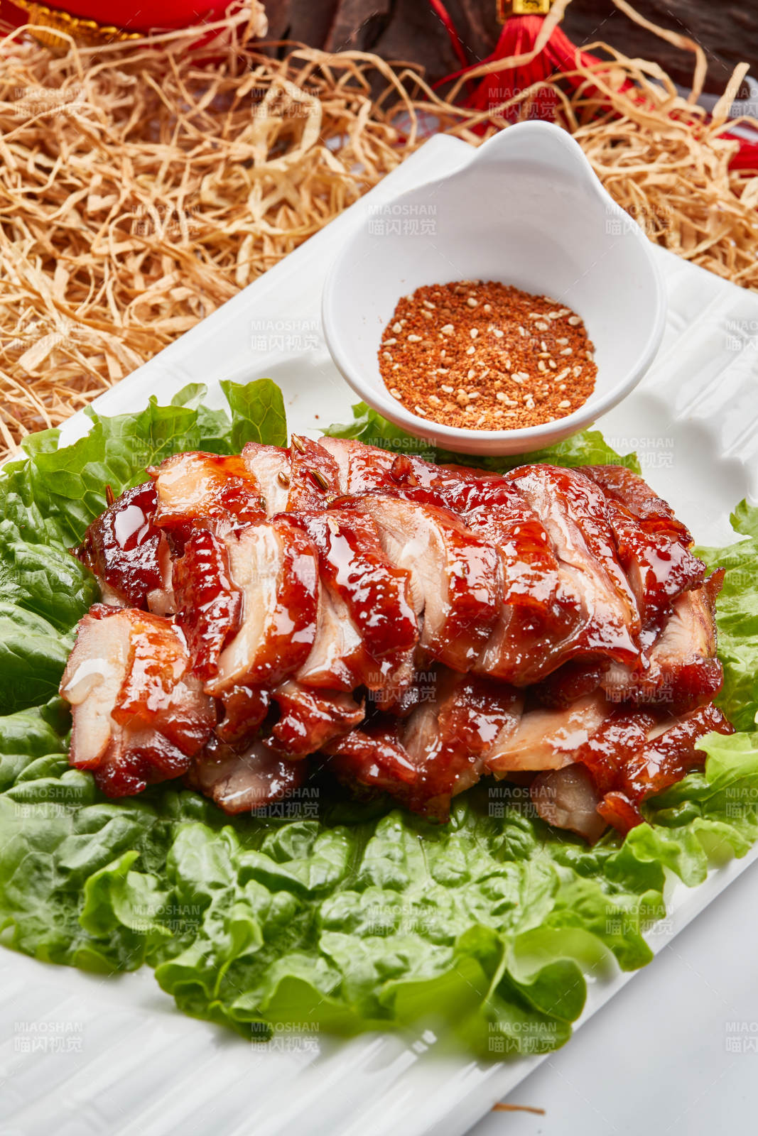 白色瓷盘装的蜜汁叉烧鸡腿肉图片