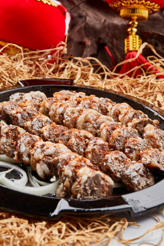 黑色铁盘装的香烤裹油羊肝图片