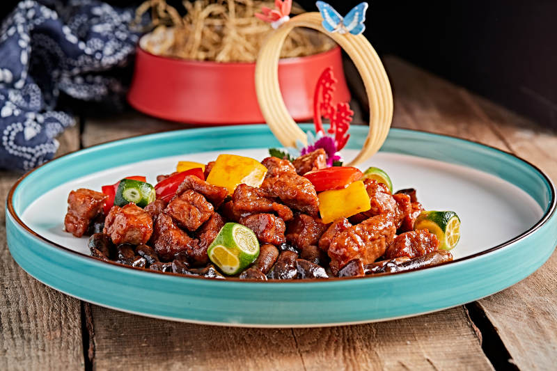 精美瓷餐具装的鸡枞菌彩椒牛仔粒图片