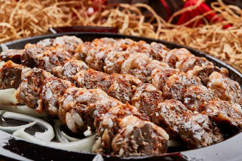 黑色铁盘装的香烤裹油羊肝图片