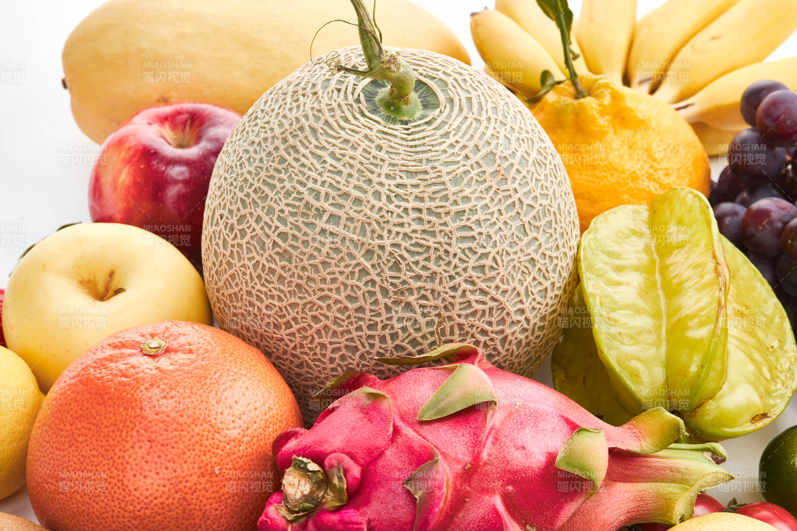 白色背景上摆放的生鲜混合水果图片