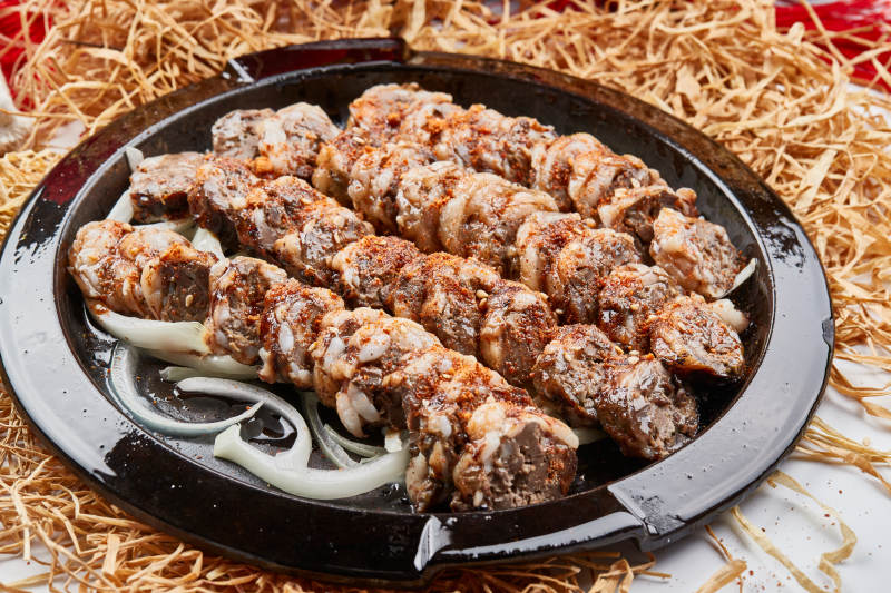 黑色铁盘装的香烤裹油羊肝图片