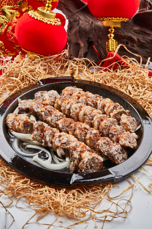 黑色铁盘装的香烤裹油羊肝图片