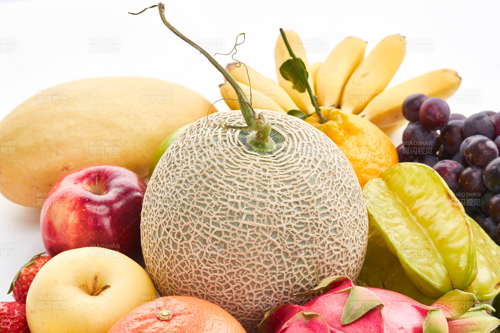 白色背景上摆放的生鲜混合水果图片